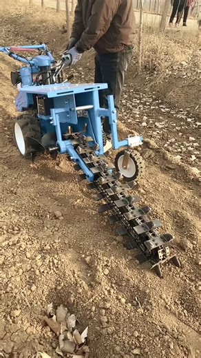 Experiment Buzz on Instagram: "The video shows a powerful, walk-behind chain trencher in action, demonstrating its ability to cut a precise, narrow ditch into dry soil. Machine Overview Design: The machine is a compact, blue-painted industrial unit with a large vertical digging boom. It features a heavy-duty chain with specialized cutting teeth, similar in appearance to a giant chainsaw. Mobility: It is equipped with two main drive tires and a smaller front-mounted guide wheel for stability and
