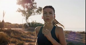 Portrait of an athletic Caucasian girl jogging. Fitness healthy lifestyle beautiful woman running and doing sports at sunset. High quality 4k footage