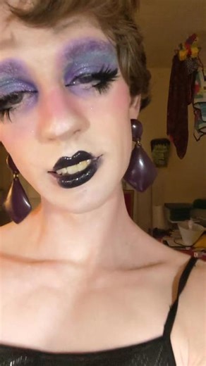 #lady in a slinky dress [ID: Gwen runs the camera up her body to show off her outfit and her face. Her slim, unpadded body is draped in a long, slinky, sparkly black dress. Her face is painted with makeup- purple eyeshadow, thick fack lashes, and black lipstick, also a soft contour with rosy red cheeks. She smiles and flutters her eyelashes at the camera.] #lgbt #trans #transqueen #transgender #enby #nb #nonbinary #genderfluid #dragqueen #drag #dragmakeup #femboy #feminization #mtftransgender #m