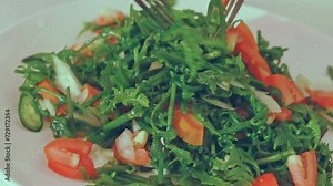 Close up to a fiddlehead fern salad or pako salad being tossed, an authentic traditional Filipino dish from the Philippines