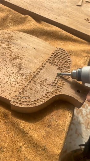 carving a beautiful honeycomb pattern into a flat wooden surface using a small electric rotary tool