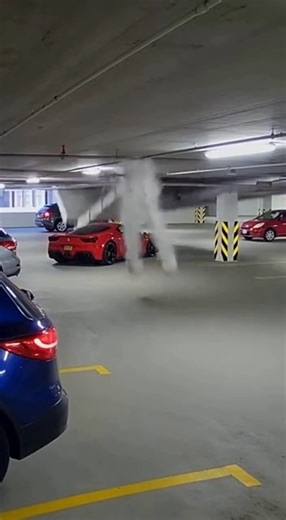 A luxury Ferrari suffered significant damage after an unusual incident inside a Beverly Hills parking garage, where a sudden burst of water poured down onto the vehicle, according to video shared online. The dramatic scene shows a powerful column of water cascading from the ceiling directly beside the red sports car, flooding the garage floor within seconds. Witnesses say the water appeared to come from a ruptured pipe or sprinkler system, releasing a forceful stream that sent mist and spray acr