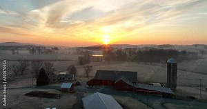Family dairy farm and barn silo buildings and barns at winter sunrise in USA. Lancaster County PA aerial.