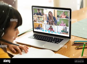 Asian girl using laptop for video call, with waving diverse elementary school pupils on screen. communication technology and online education, digital Stock Photo - Alamy