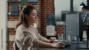 Programer typing source code on computer keyboard turning head and smiling at camera. Casual software engineer sitting at desk in it startup company writing ai algorithm feeling confident.