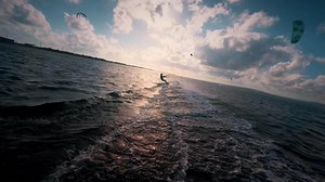 Young man kite surfing. Extreme kite boarding in slow motion. Summer fun action sports. Happiness in nature