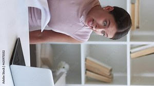 Vertical video. Angry boss. Work conflict. Internet business call. Irritated business woman yelling at laptop gesticulating throwing papers at office.