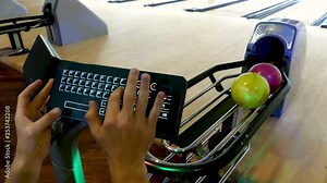 Typing player names on the system of a bowling alley.