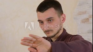 Focused man practicing tai chi exercise repulse monkey on stony wall background. Concentrated man training traditional qigong martial gymnastics