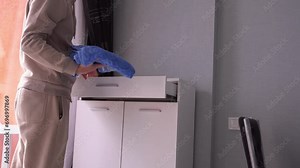 A man takes out a towel from a white chest of drawers, housework, cleaning, morning procedures, washing, taking a shower