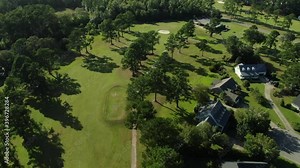 Golf course, oak trees, greens and golf carts with people playing on 18 hole course in Georgetown, South Carolina