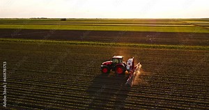 Farmer in tractor spraying industrial soybean crops