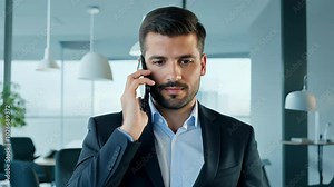 Serious businessman making a phone call in a corporate office, focused on a professional conversation. video