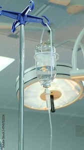 Vitamin IV drip chamber dripping on medical clinic. Dripping for intravenous infusion during surgery. Vertical video