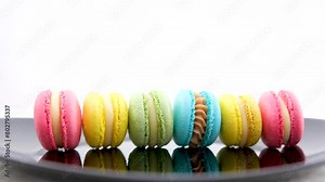 beautiful multi-colored pasta blue yellow pink green on a black plate white background whirl ride ride cook delicious french dessert lunch different toppings female hands cook tasty