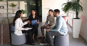 Diverse group of young business colleagues meeting in co-working space for offline communication, work discussion, cooperation, sitting in circle, talking, discussing startup project strategy