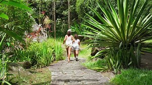 Sisters, daughters walking an old concrete steps between plants inside the botanical garden, Mahe Seychelles 2
