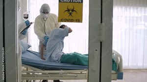 Professional doctor wearing protective overall suit working as teamwork in hospital negative room in hurry save patient suffering breath from corona virus outbreak infection treatment.