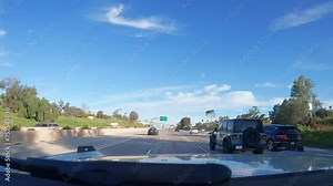 Los Angeles, California USA - 08 18 2023 : Driving on intercity freeway in California USA. Defocused view from car thru glass windshield. Blurred suburb multiple lane driveway. Camera inside auto