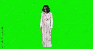 Full length of scary zombie woman with wounded and bloody face standing against green screen background, shot in 4k resolution