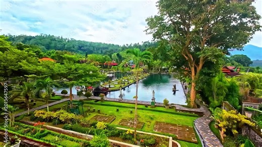 Stone bathing pools and gardens at Tirta Empul temple with clear water and surrounding greenery, Bali, Indonesia