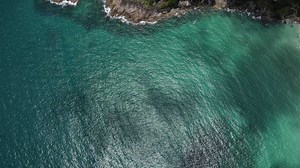 Download Aerial view of sand beach and water surface texture. Foamy waves with sky. Beautiful tropical beach. Amazing sandy coastline with white sea waves. Nature, seascape and summer concept. for free
