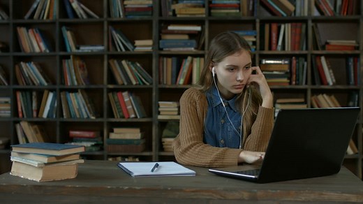 Girl doing homework in a library - Free Stock Video