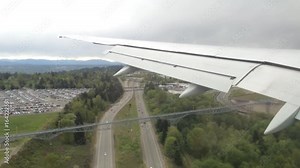 Looking trough window of an aircraft, airplane or plane wing. View from plane window during landing or takeoff over the city urban area