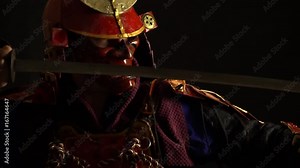 Samurai in a red armor and helmet demon mask becomes a defensive pose with a katana
