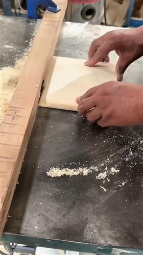shaping the edge of a light wooden piece using a sharp electric table saw machine in a workshop