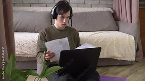 Student with headphones and a microphone study online at home. Distance education. Remote working during Coronavirus Covid-19 lockdown