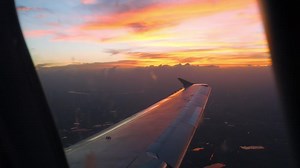Beautiful sunset over the city, view from the airplane window. Airplane sunrise flight. Traveling by air