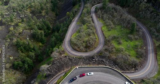 A tilting aerial DJI drone shot of the Rowena Crest Viewpoint in Mosier Oregon on the Columbia River Gorge National Scenic Area with tourists parked on top enjoying the view after driving windy roads