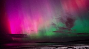 aurora australis taking on a sandy beach in a beach town in tasmania australia in winter