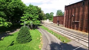 Aerial pull back from the rear of the Wilbur Chocolate building to reveal the entrance to the Lititz Springs Park Concept: family, community, June, park, small-town life, lifestyle