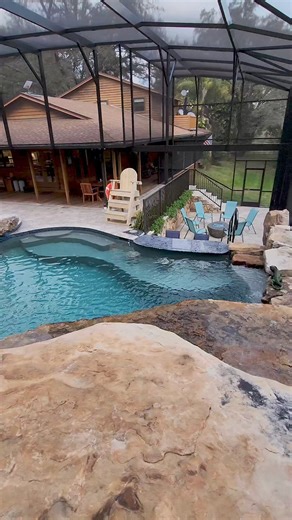 2.9M views · 10K reactions | Insane Pool recently completed in Central Florida. This backyard has a huge grotto, a waterslide, a big spa, a swim-up bar, a screened enclosure, a fire pit, and a lifeguard stand. | Lucas Lagoons Design | Facebook