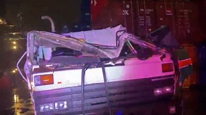 Strong winds "blow" shipping container off a stack and onto a truck, injuring the driver