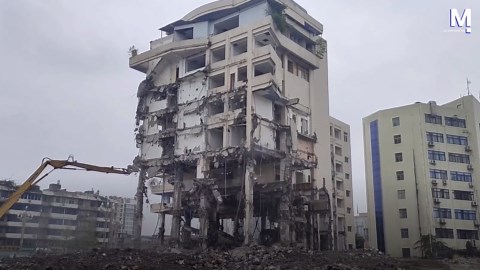 Excavator brings down building in controlled demolition