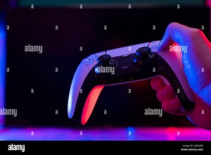 Modern gamepad in a gamer's hand on a dark background. Minimalism. Video games with friends, competitions, tournaments, battles. Prizes, win, new mode Stock Photo - Alamy
