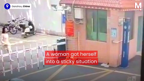 Hapless woman gets herself pinned against wall by parking barrier
