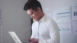 Asian Businessman using laptop computer Does Data Analysis Works on e-Commerce Startup in office.