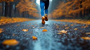 Download A Runner's Journey Through Autumn Rain on a Scenic Path for free