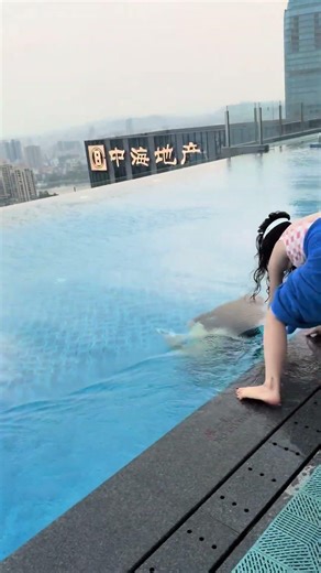 Person falls into swimming pool while filming a swimmer underwater in Guangdong, China