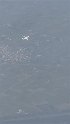 "Shot on Galaxy S24 – unreal window view of another plane cruising right below us"