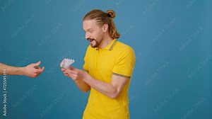 Pleased man accepts offered banknotes as bribe in studio