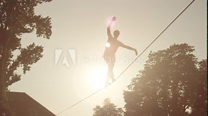 Man balancing on slackline between the houses in big city