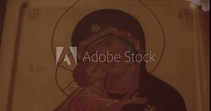 Hand wipes white cloth drawing icons in the church. Kisses the object in the bokeh. A dark room for prayer for financial growth.