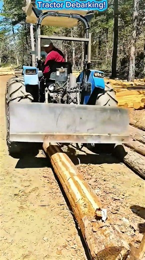 Tractor Debarking a Giant Log with a Logging Blade.