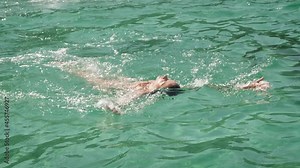 woman is floating on her back in the ocean, the sea. Clear turquoise water.