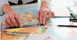 Cartographer with ruler makes measurements on world map
